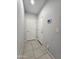 Hallway with tile floors, light gray walls, white doors, and a modern thermostat display at 19954 W Moonlight Path, Buckeye, AZ 85326