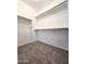 Carpeted walk-in closet with white shelving for ample storage space at 19954 W Moonlight Path, Buckeye, AZ 85326
