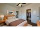 Bright bedroom features a ceiling fan, a modern light fixture, and an open closet with ample space at 22507 N 31St Ave # 11, Phoenix, AZ 85027