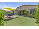 Spacious backyard featuring lush lawn, covered patio, and inviting lounge area with umbrellas at 2466 E Aris Dr, Gilbert, AZ 85298