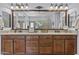 Bathroom with dual sinks, granite countertop, wood cabinets, dual mirrors, glass block wall and tile floor at 2466 E Aris Dr, Gilbert, AZ 85298