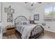 Cozy bedroom with wood-look ceramic tile flooring, a metal bedframe, and neutral wall color at 2466 E Aris Dr, Gilbert, AZ 85298
