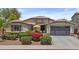 Charming single-story home with desert landscaping, a two-car garage, and a cozy front patio with yellow umbrella at 2466 E Aris Dr, Gilbert, AZ 85298