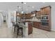 A spacious kitchen features dark wood cabinets, granite countertops, a center island with seating, and stainless steel appliances at 2466 E Aris Dr, Gilbert, AZ 85298