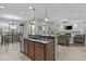 Open concept kitchen with a large island, pendant lighting, stainless steel appliances, and seamless flow to the living area at 2466 E Aris Dr, Gilbert, AZ 85298