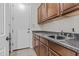Practical laundry room with wood cabinets, sink, and direct access to the exterior at 2466 E Aris Dr, Gilbert, AZ 85298