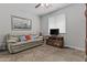 Relaxing living room with a plush sofa, TV, and a bright window at 2466 E Aris Dr, Gilbert, AZ 85298