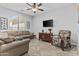 Cozy living room featuring a large window, tan sofa, and a patterned accent chair at 2466 E Aris Dr, Gilbert, AZ 85298