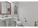 Functional powder room with pedestal sink, toilet, and decorative mirror at 2466 E Aris Dr, Gilbert, AZ 85298
