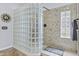 Walk-in shower features glass block partition, stone surround, showerhead and handheld sprayer at 2466 E Aris Dr, Gilbert, AZ 85298