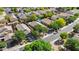 Aerial view of a residential area with lush trees, backyard pools, and neatly arranged houses on a bright day at 2551 W Sawtooth Way, San Tan Valley, AZ 85144