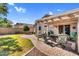 Backyard featuring a covered patio with comfortable outdoor seating and manicured lawn at 2551 W Sawtooth Way, San Tan Valley, AZ 85144