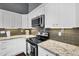 Modern kitchen showcasing white cabinetry, stainless steel appliances, and stylish backsplash at 2551 W Sawtooth Way, San Tan Valley, AZ 85144