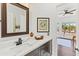 Bathroom with dark wood vanity, white marble countertop, and view to bright home office at 30600 N Pima N Rd # 81, Scottsdale, AZ 85266