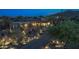 Desert home featuring lush landscaping, saguaro cacti, and landscape lighting throughout the front yard at 30600 N Pima N Rd # 81, Scottsdale, AZ 85266