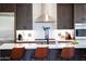 Modern kitchen featuring stainless steel appliances, white countertops, and dark cabinetry with an eat-in kitchen island at 30600 N Pima N Rd # 81, Scottsdale, AZ 85266