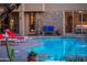 Backyard patio with a beautiful stone wall, a cozy fireplace, and lounge chairs by the shimmering pool at 30600 N Pima N Rd # 81, Scottsdale, AZ 85266