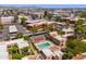 Stunning aerial view of a community with a pool, mature trees, and surrounding commercial buildings at 3131 W Cochise Dr # 144, Phoenix, AZ 85051