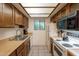 Functional kitchen with vintage wood cabinetry, light countertops, and modern appliances at 3131 W Cochise Dr # 144, Phoenix, AZ 85051