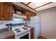 Traditional kitchen with wood cabinets, updated countertops, and white stove appliance at 3131 W Cochise Dr # 269, Phoenix, AZ 85051