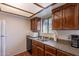 View of the traditional kitchen featuring wood cabinets, updated countertops, and stainless steel sink at 3131 W Cochise Dr # 269, Phoenix, AZ 85051