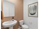 Cozy powder room featuring patterned wallpaper, a stylish mirror, and a modern vessel sink at 38065 W Frascati Ave, Maricopa, AZ 85138
