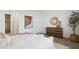 A serene bedroom featuring a white bed, wood dresser, neutral decor, and natural light at 38065 W Frascati Ave, Maricopa, AZ 85138
