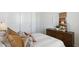 Cozy bedroom features a wooden dresser, white linens, neutral decor, and natural light at 38065 W Frascati Ave, Maricopa, AZ 85138