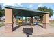 Shaded playground area with picnic tables and a grill, perfect for Gathering gatherings and community events at 38065 W Frascati Ave, Maricopa, AZ 85138
