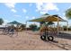 Community playground with swings, slides, and covered play areas, promoting outdoor fun and exercise at 38065 W Frascati Ave, Maricopa, AZ 85138