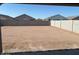 Large backyard, enclosed by a tall block wall, providing privacy and space for outdoor activities at 38100 W Bello Ln, Maricopa, AZ 85138