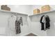Organized walk-in closet with clothing racks and storage boxes on shelves at 38100 W Bello Ln, Maricopa, AZ 85138