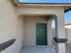 Welcoming front entrance with a stylish dark green door, covered porch, and a decorative pillar at 38100 W Bello Ln, Maricopa, AZ 85138