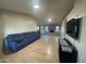 Spacious living room with light wood floors, blue sofa, fireplace, and TV; ideal for relaxation and entertainment at 405 E Providence Dr, Casa Grande, AZ 85122