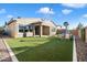 Wide view of home's backyard with low maintenance turf, outdoor seating and covered patio at 4050 S Thistle S Dr, Chandler, AZ 85248