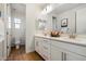 Bright and spacious bathroom features double sinks, white cabinets and wood-look flooring at 4050 S Thistle S Dr, Chandler, AZ 85248