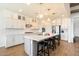 Well-lit kitchen featuring white cabinetry, subway tile backsplash, and a spacious island with seating at 4050 S Thistle S Dr, Chandler, AZ 85248