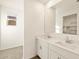 Bright bathroom boasts double sinks, white cabinetry, and a large mirror reflecting the walk-in closet at 4167 W Lisa Ln, San Tan Valley, AZ 85144
