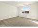 Spacious bedroom featuring neutral carpeting, a sunny window view, and fresh white walls at 4167 W Lisa Ln, San Tan Valley, AZ 85144