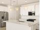 Kitchen featuring a large island, stainless steel appliances, pendant lights, and white cabinetry at 4167 W Lisa Ln, San Tan Valley, AZ 85144