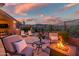 Desert home boasts a beautiful back patio with outdoor seating and a fire pit at 41731 N Rolling Green Way, Anthem, AZ 85086