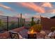 Desert home's back patio with an inviting fire pit, desert landscaping, and cactus at 41731 N Rolling Green Way, Anthem, AZ 85086