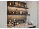 The custom bar with lit shelving offers plenty of storage and complements the entertainment space at 41731 N Rolling Green Way, Anthem, AZ 85086