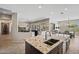 Open kitchen with a large center island featuring granite countertops and stainless steel sink at 41731 N Rolling Green Way, Anthem, AZ 85086
