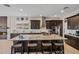 Spacious kitchen island with granite countertops, bar seating, dark wood cabinets, and stainless steel appliances at 41731 N Rolling Green Way, Anthem, AZ 85086