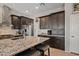 Modern kitchen with granite countertops, stainless steel appliances, and dark wood cabinetry at 41731 N Rolling Green Way, Anthem, AZ 85086