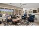 Open-concept living room with fireplace, plantation shutters and views into the kitchen and dining areas at 41731 N Rolling Green Way, Anthem, AZ 85086
