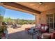 Spacious covered patio featuring desert views, lounge chairs, and cozy seating at 41731 N Rolling Green Way, Anthem, AZ 85086