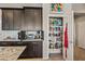 Kitchen cabinets and fully stocked walk-in pantry with ample storage shelving and an open door at 41731 N Rolling Green Way, Anthem, AZ 85086