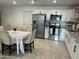 Well-lit kitchen featuring white cabinets, stainless steel appliances, granite countertops, and a dining table at 4602 N 47Th N Ave, Phoenix, AZ 85031